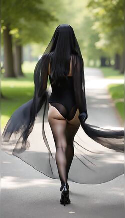 Elegant Model Walking Through Park in Flowing Black Veil